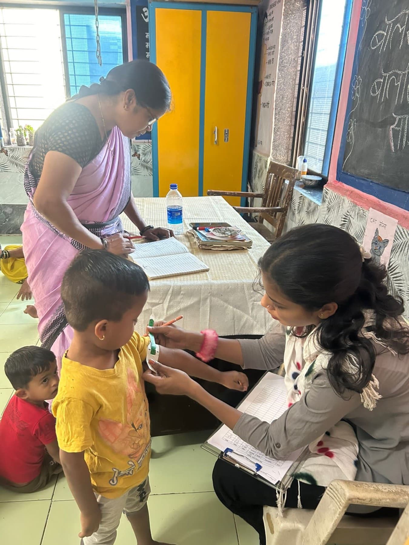 A weighing scale in use at a health screening, part of a routine growth measurement.